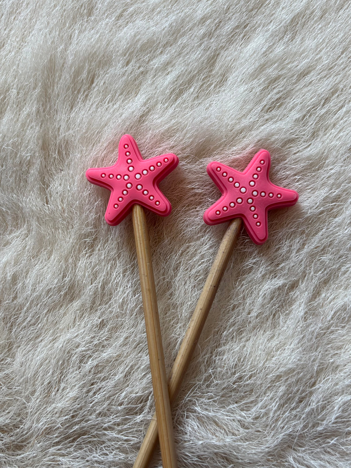 Pink Starfish knitting needle point protectors.
