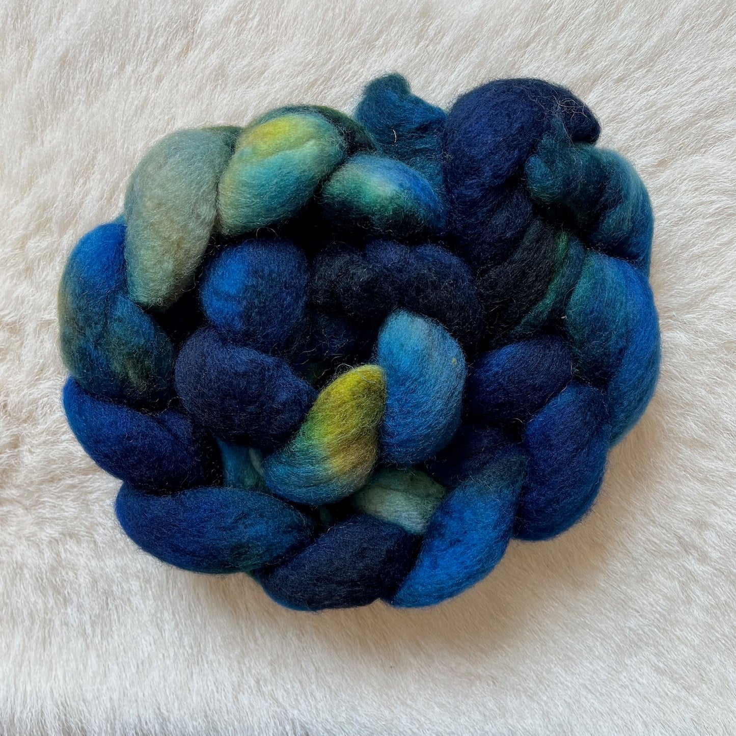 BFL Spinning or felting fiber hand dyed in shades of blended blue, teal, green, and small yellow-green highlights